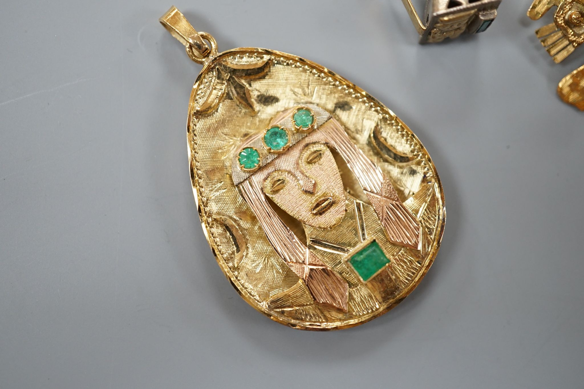 A South American 18k yellow metal and emerald set pendant, 39mm, a similar gem set brooch and ring